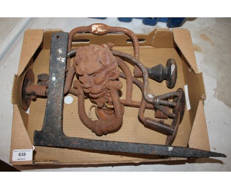 A box containing a boot scraper; old hand braces; lion head door knocker