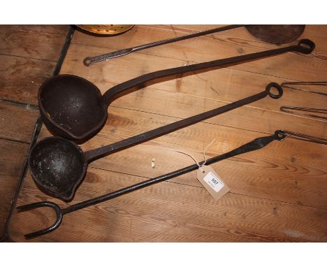 Two large metal ladles and a large metal toasting fork