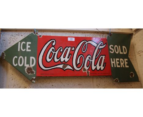 An enamel arrow shaped advertising sign for Coca Cola, (30cm x 76cm approx.)