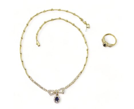 AN ARABIC GOLD NECKLACE AND RING set with blue and clear gems to the bow motif, length of necklace approx 43cm, the ring size