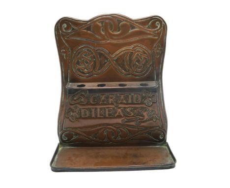 AN ALEXANDER RITCHIE OF IONA COPPER PIPE RACK with repousse decoration of Celtic knotwork and stylised foliage, with Gaelic m