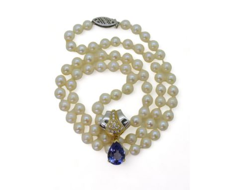 A TANZANITE AND DIAMOND PEARL CLIP made in 18ct yellow and white gold, set with a pear-shaped tanzanite of approx 7mm x 10mm,