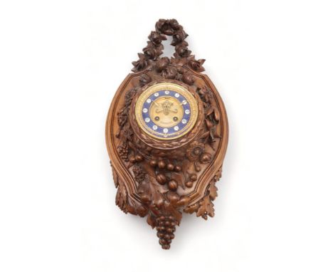 A 19TH CENTURY BLACK FOREST WALL CLOCK carved profusely with fruits, flowers and foliage, the gilded dial with engine turned 