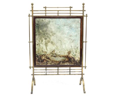 A VICTORIAN BRASS FRAMED FIRESCREEN&nbsp; with glazed panel reverse painted with scene depicting birds bathing amongst woodla