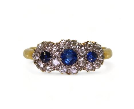 A THREE FLOWER CLUSTER RING set with three round cut sapphires surrounded with old cut diamonds with a combined estimated app