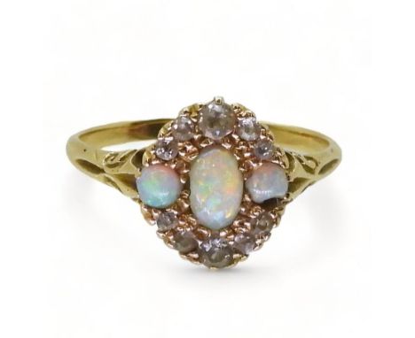 AN 18CT GOLD VINTAGE RING set with three opals and old cut diamonds. With galleried mount and scroll detailed shoulders. Fing