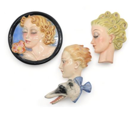 A GOEBEL WALL MASK BY AGNES RICHARDSON modelled as a girls head with curly blonde hair, no R24, 21.5cm high, together with tw
