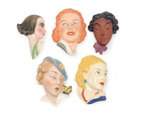 A COLLECTION OF CZECHOSLOVAKIAN ART DECO WALL MASKS all of girls' heads, including a Royal Dux example of a girl with a butte