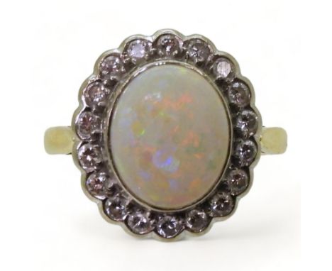 AN OPAL & DIAMOND CLUSTER RING set with a 11mm x 9mm lively white opal, surrounded with estimated approx 0.36cts of brilliant