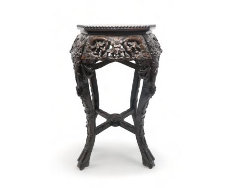 A CHINESE CARVED HARDWOOD MARBLE STAND the circular top above four openwork foliate carved aprons, with foliate carved cabrio