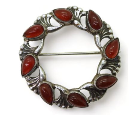 A BROOCH BY SIBYL DUNLOP set with eight teardrop shaped carnelians interspaced with sprays of silver berries. Signed verso S.