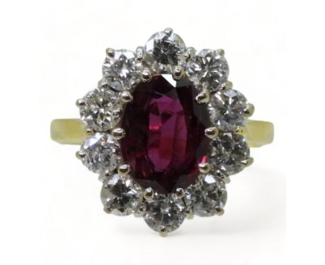 A RUBY AND DIAMOND CLUSTER RING mounted in a classic 18ct gold basket mount, set with a oval cut ruby of 9.3mm x 7mm x 3.2mm,