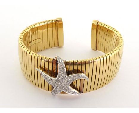 An Italian 18 carat gold and diamond cuff bangle, of ribbed design, set to the centre with a pave set single cut starfish mot