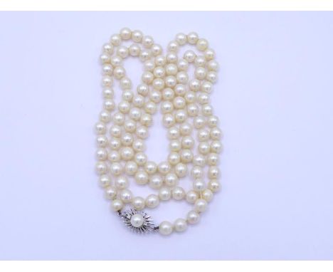 A single strand of cultured pearls, composed of uniform 7mm pearls, to a white metal clasp (tests 18 carat gold), diamond and