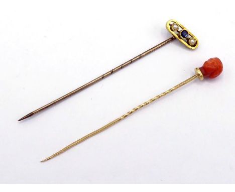 An early 20th century sapphire and split pearl stick pins, the oblique head set with three small gems, the mount (tests 14 ca