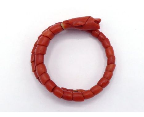 A Victorian carved coral 'serpent' bangle, composed of articulated scales on a wire, 4.4cm inner diameter CONDITION: glued re