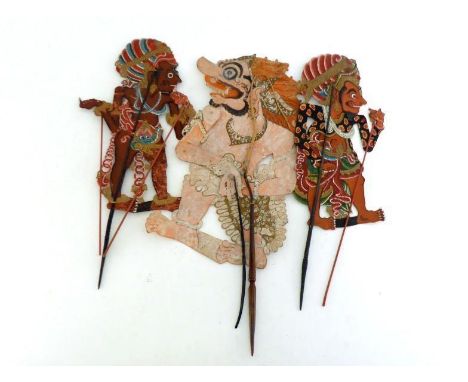 Three Indonesian articulated shadow puppets elaborately painted on both sides, pierced and with stick operation of the limbs.