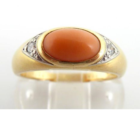 Van Cleef & Arpels, an 18 carat gold, coral and diamond ring, the coral cabochon 8 x 5mm, bracketed by two small brilliants, 