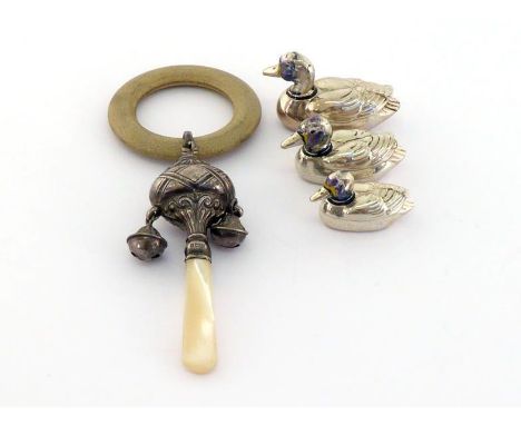 A family of three modern graduated silver toy ducks with traces of enamel to heads ; also a silver child's rattle with two be