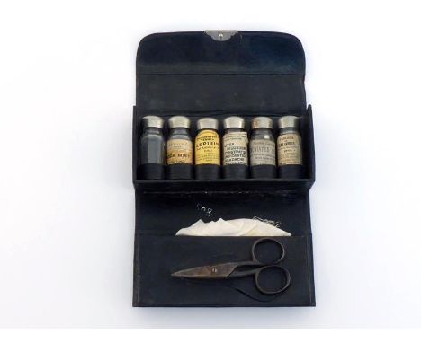 A folding black leather pocket First Aid case with six screw top bottles, five with original labels, gauze bandage and scisso