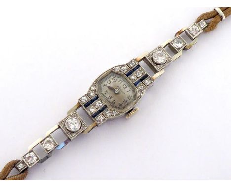 An Art Deco platinum, diamond and sapphire cocktail watch, the shaped rectangular bezel set with single cuts and calibre cut 