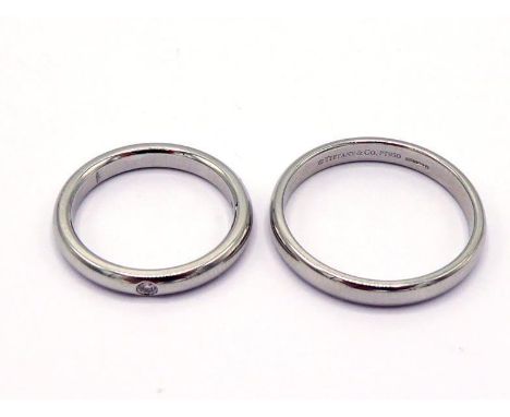 TIFFANY, two platinum bands, the smaller rub over set with a small brilliant, the smaller by Elsa Peretti, both signed and ha