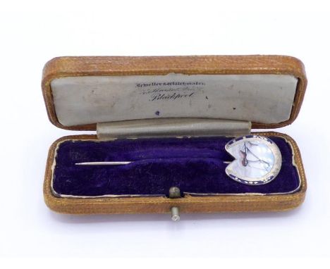 SAILING INTEREST: a late Victorian enamel and silver stick pin, the head in the form of a hourseshoe, the image to the centre