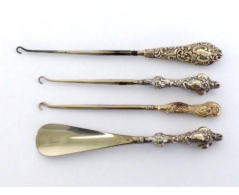 Three late Victorian and Edwardian silver-handled button hooks, one with a matching shoe horn, all with decorative handles, B