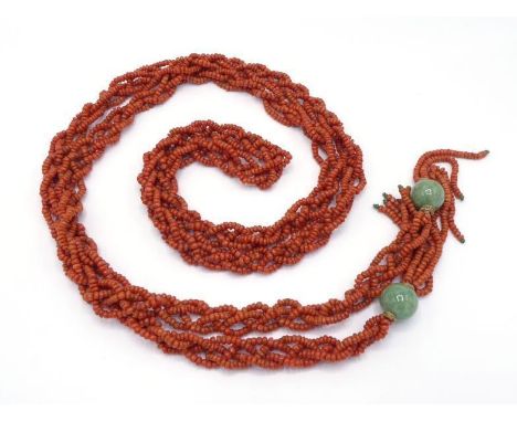 A 20th century Chinese coral and jadeite robe cord, composed of four strands of braided coral, to large jadeite bead terminal
