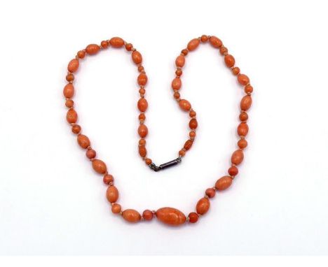 An early 20th century coral bead necklace, composed of alternate oval and spherical beads, individually knotted, to a bolt cl