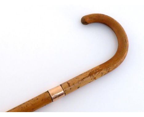 A lacquered malacca cane walking stick with plain 12 carat gold band, London 1919.. Length 89cm. 