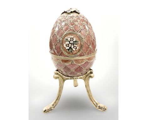 An enameled musical Fabergé-style egg on gilt metal stand.