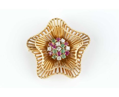 A ruby, emerald and diamond set panel brooch, the tiered and undulating star-shaped panel centred with a pavé set cluster of 