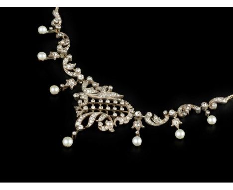 A late 19th/early 20th century diamond and pearl fringe necklace/tiara ornament, centred with an asymmetric cartouche of foli