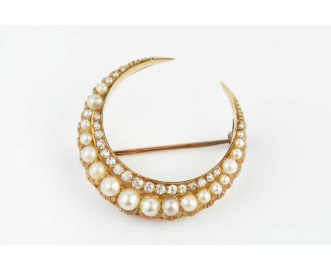 A late Victorian/Edwardian half pearl and diamond crescent brooch, the row of graduated half pearls edged with old and single
