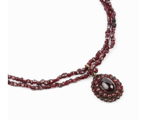 A garnet cluster pendant necklace, the cluster pendant centred with an oval cabochon garnet in closed-back setting, bordered 