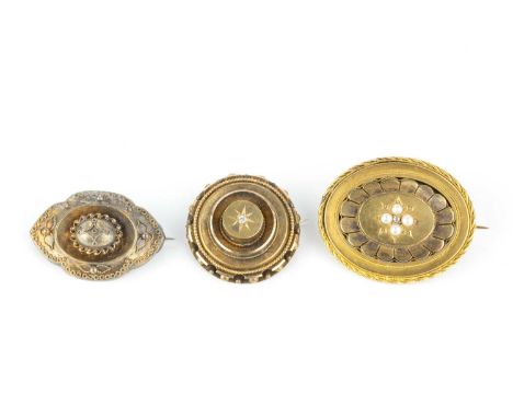 Three Victorian panel brooches, comprising a half pearl and diamond set panel brooch, of tiered oval form, with ropetwist wir