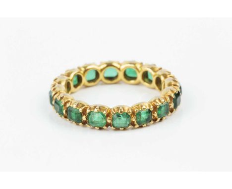 A 19th century emerald full hoop eternity ring, set throughout with rectangular step-cut emeralds in pinched collet settings,