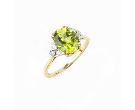 A peridot and diamond dress ring, the oval mixed-cut peridot claw set between pierced and millegrained shoulders of round bri