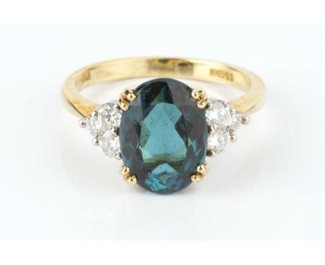 A blue tourmaline and diamond dress ring, the oval mixed-cut blue tourmaline claw set between trios of round brilliant-cut di