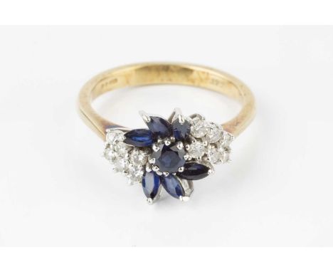 A sapphire and diamond cluster ring, designed as an abstract spray of circular mixed-cut and navette-shaped sapphires, framed