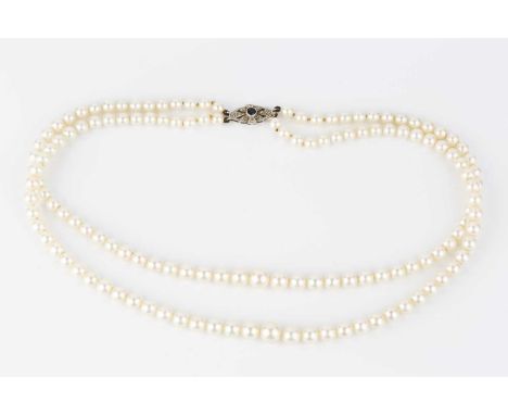 A cultured pearl necklace with gem set clasp, comprising two strands of graduated cultured pearls, to an openwork lozenge-sha