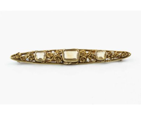 An Arts and Crafts style citrine and pearl panel brooch, the elongated openwork navette-shaped panel applied with a trio of c