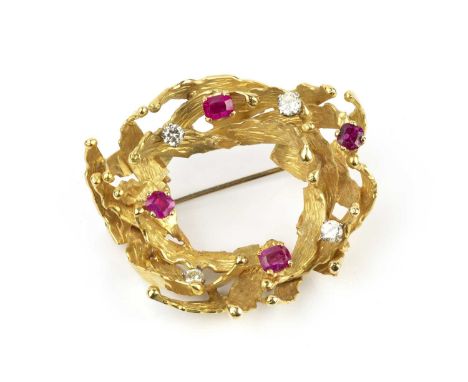 A ruby and diamond panel brooch by Alan Martin Gard, the openwork wreath of textured abstract design, highlighted by scatter 