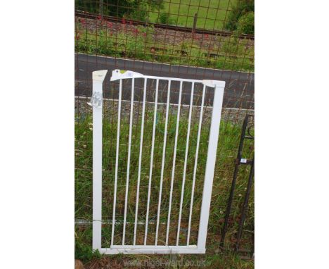 A white pet gate, 28" wide x 43" high.