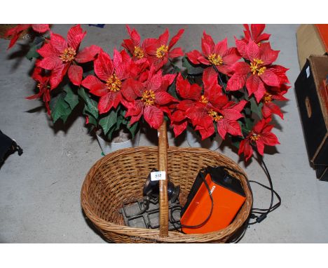 A dark room Ilford safety light, two artificial Poinsettia plants and a basket.