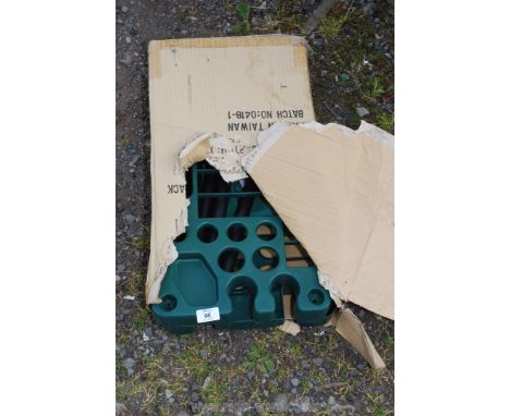 A green plastic garden tools rack.