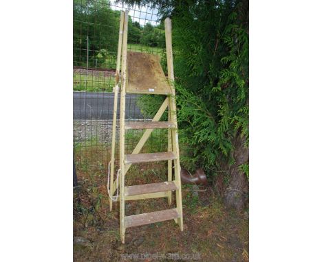 A five rung wooden step ladder painted in yellow.