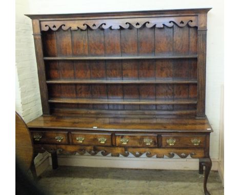 A Regency style oak shelf back dresser with three shelves over a four drawer base and pierced work brass handles on cabriole 