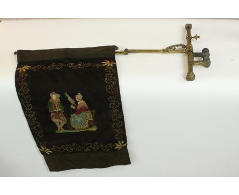 A Victorian embroidered brass extendable fire screen. Decorated with a couple withing a stylised foliate and floral border.  